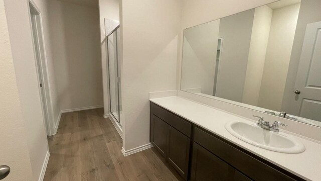 bathroom with vanity, an enclosed shower, and hardwood / wood-style floors