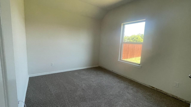 carpeted empty room with vaulted ceiling