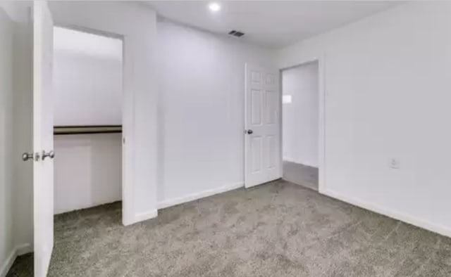 unfurnished bedroom featuring a closet and light carpet