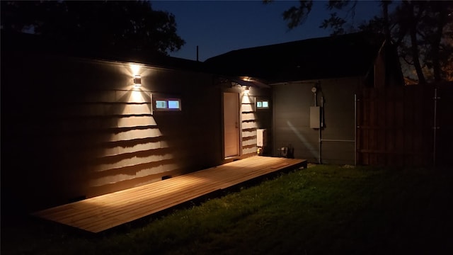 back house at night with a wooden deck