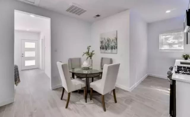 dining space with plenty of natural light and light hardwood / wood-style flooring