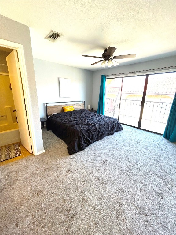 bedroom with carpet flooring, access to exterior, ceiling fan, connected bathroom, and a textured ceiling