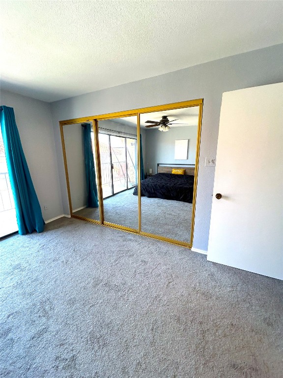 unfurnished bedroom with carpet, a closet, and a textured ceiling