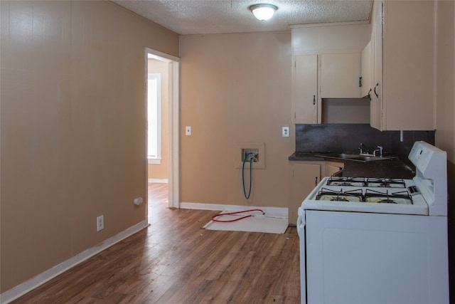 kitchen with white cabinets, white range with gas cooktop, wood-type flooring, a textured ceiling, and sink