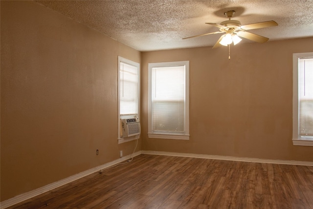 empty room featuring ceiling fan, a textured ceiling, dark wood-type flooring, and plenty of natural light