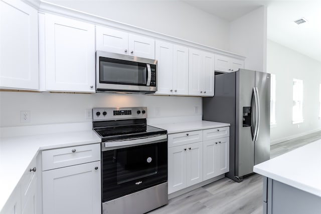 kitchen featuring stainless steel appliances, light hardwood / wood-style floors, and white cabinets