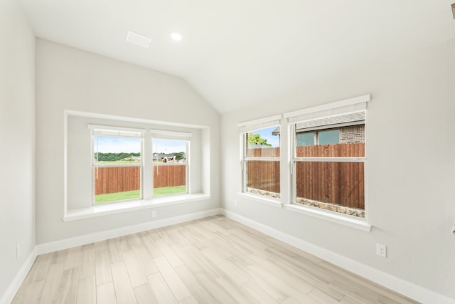 empty room with lofted ceiling and light wood-type flooring