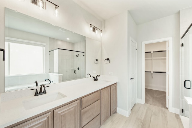 bathroom with hardwood / wood-style floors, vanity, and a shower with shower door