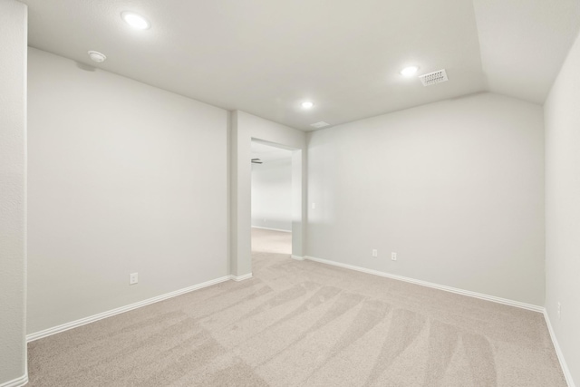 empty room featuring light carpet and lofted ceiling