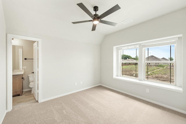 unfurnished bedroom featuring ensuite bathroom, ceiling fan, lofted ceiling, and light carpet