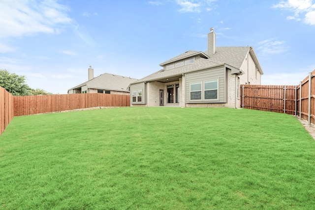 rear view of house featuring a lawn