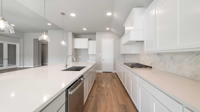 kitchen with white cabinets, decorative light fixtures, hardwood / wood-style floors, and appliances with stainless steel finishes