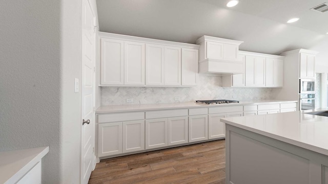 kitchen with white cabinetry, stainless steel appliances, tasteful backsplash, dark hardwood / wood-style flooring, and custom exhaust hood