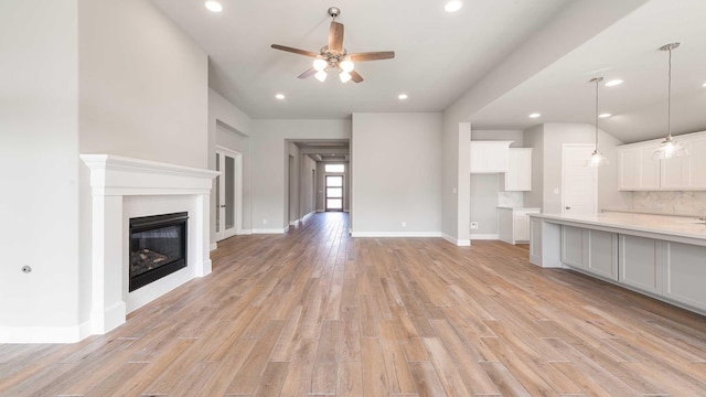 unfurnished living room with ceiling fan and light wood-type flooring