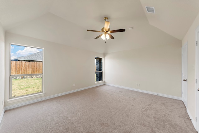 empty room with ceiling fan, lofted ceiling, and light colored carpet