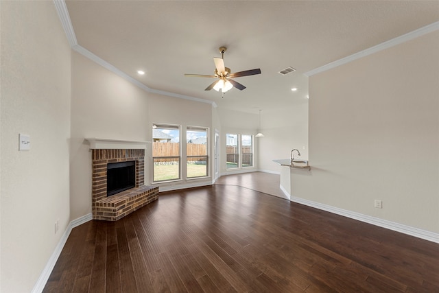 unfurnished living room featuring dark wood-type flooring, a fireplace, and crown molding