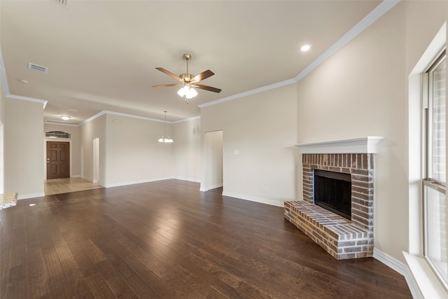 unfurnished living room with ceiling fan, dark wood-type flooring, ornamental molding, and a brick fireplace