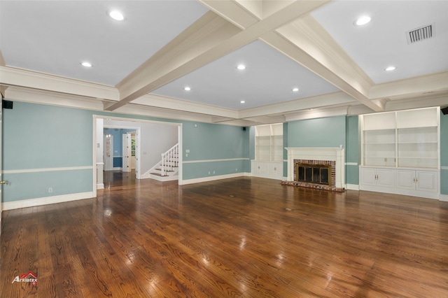 unfurnished living room with beam ceiling, hardwood / wood-style floors, ornamental molding, and a fireplace