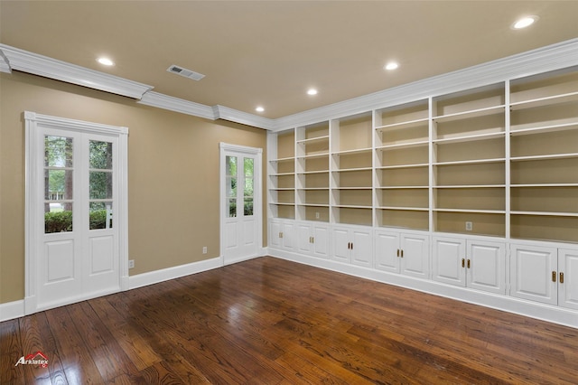 unfurnished room with built in shelves, ornamental molding, a wealth of natural light, and dark hardwood / wood-style floors