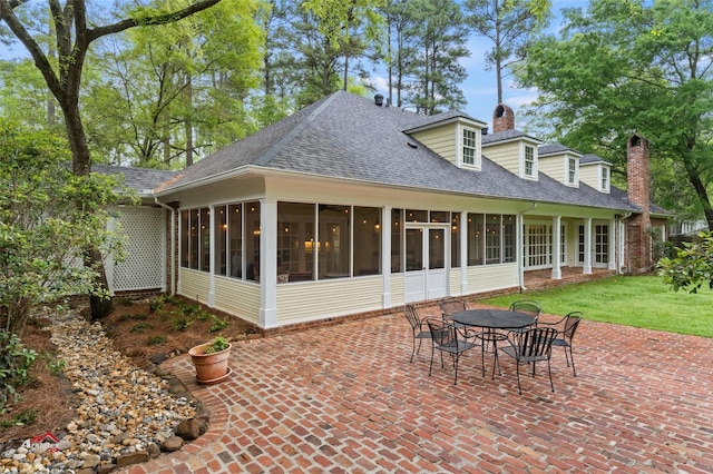 back of house with a lawn, a patio area, and a sunroom