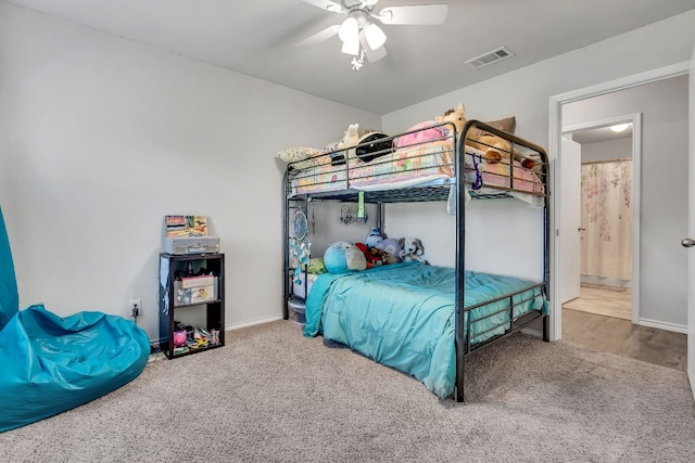 carpeted bedroom featuring ensuite bath and ceiling fan