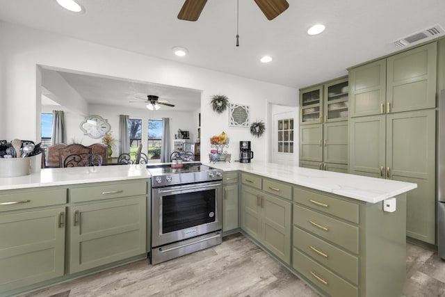 kitchen with green cabinetry, stainless steel electric stove, ceiling fan, and light wood-type flooring