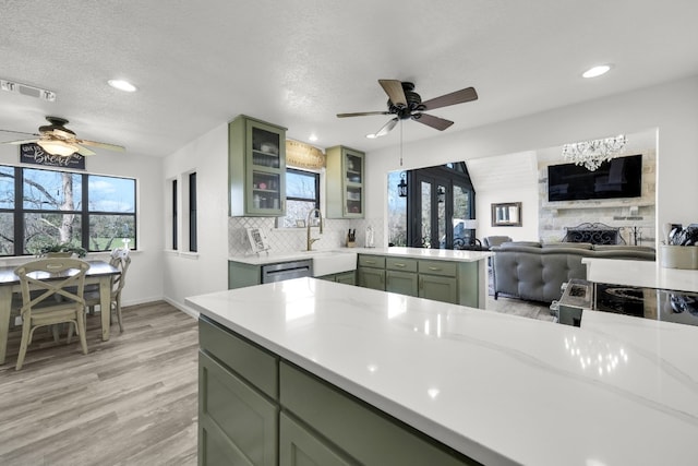 kitchen featuring light hardwood / wood-style floors, ceiling fan, a textured ceiling, and a fireplace