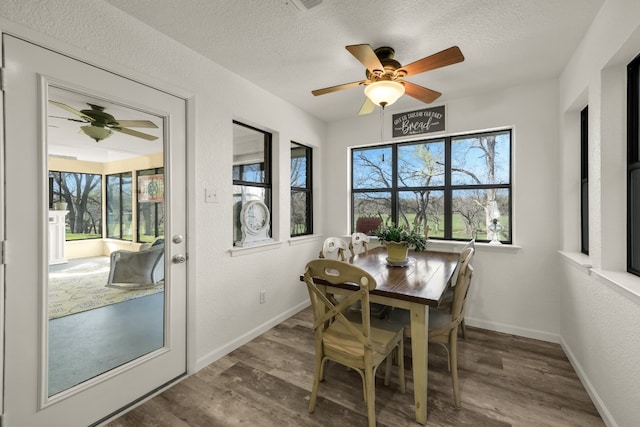 dining area with a textured ceiling, dark hardwood / wood-style floors, ceiling fan, and a wealth of natural light