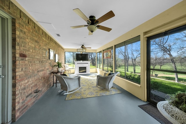 unfurnished sunroom featuring ceiling fan