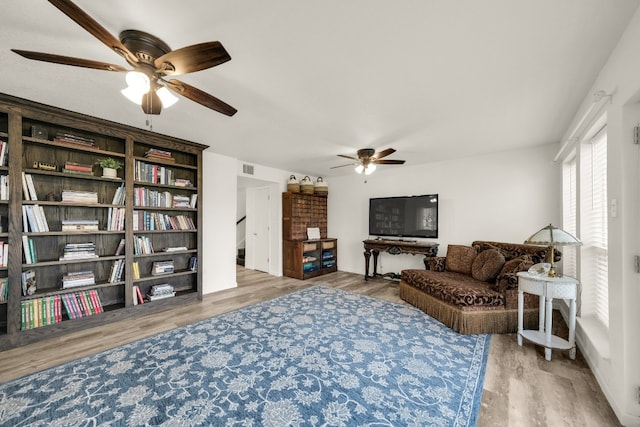 living area featuring ceiling fan and light hardwood / wood-style flooring