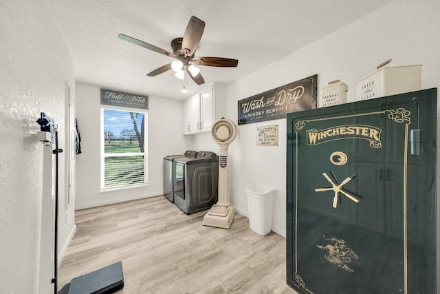 interior space featuring ceiling fan, cabinets, light wood-type flooring, a textured ceiling, and separate washer and dryer