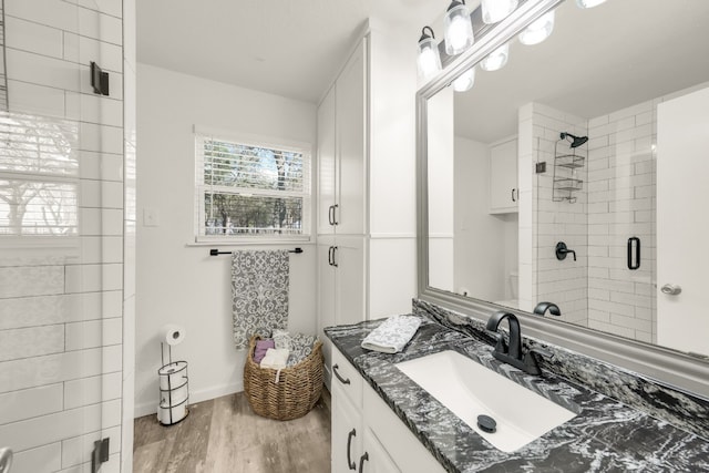 bathroom featuring vanity, wood-type flooring, and a shower with door