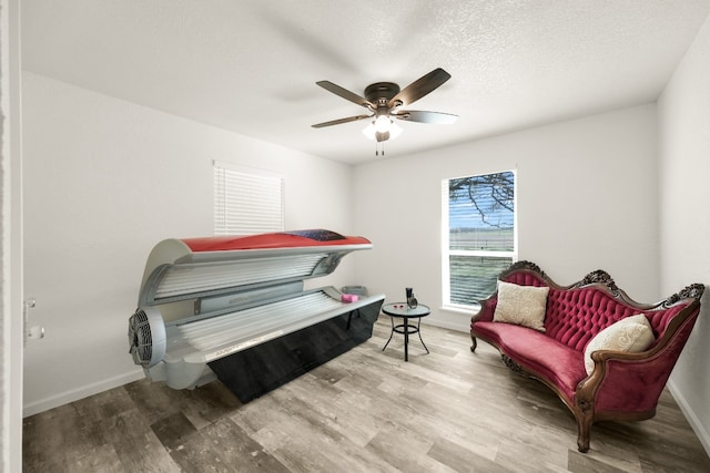 sitting room featuring a textured ceiling, ceiling fan, and light wood-type flooring