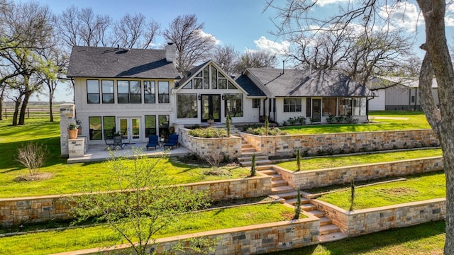 rear view of house featuring a yard and a patio area