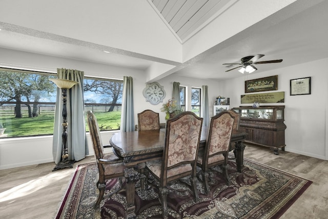 dining space with a healthy amount of sunlight, ceiling fan, vaulted ceiling, and light hardwood / wood-style flooring