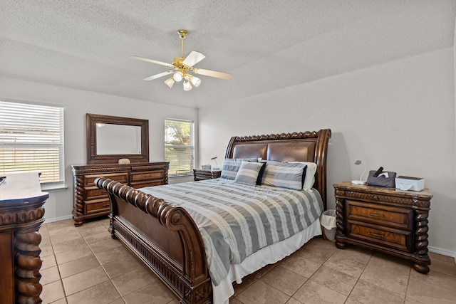 tiled bedroom with ceiling fan, a textured ceiling, and multiple windows