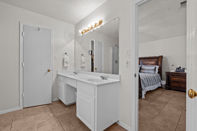 bathroom featuring double sink vanity, a textured ceiling, and tile patterned flooring