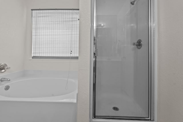 bathroom featuring independent shower and bath