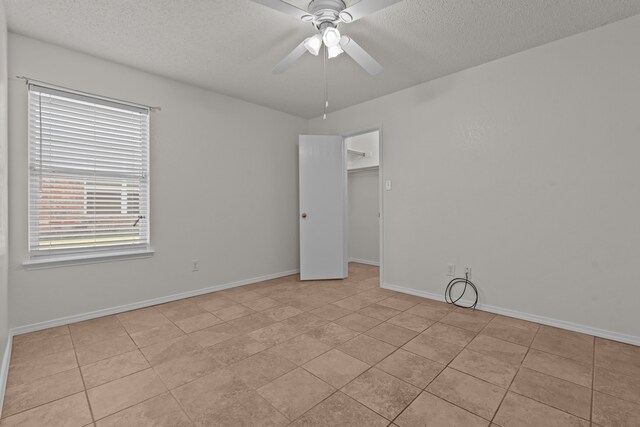 tiled spare room featuring ceiling fan and a textured ceiling