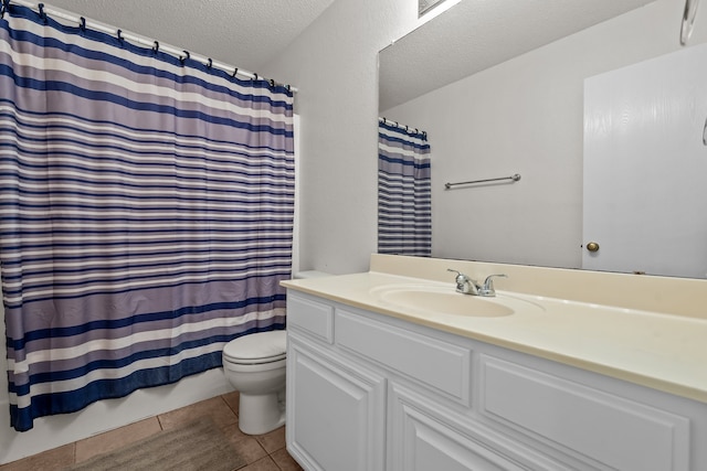 bathroom with vanity, a textured ceiling, toilet, and tile patterned flooring