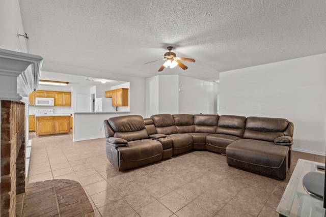 living room featuring ceiling fan, light tile patterned flooring, and a textured ceiling