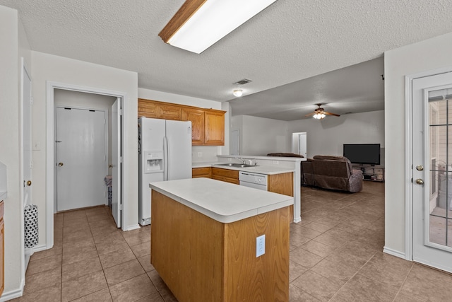 kitchen featuring ceiling fan, white appliances, a kitchen island, and light tile patterned floors