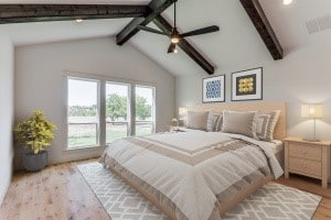 bedroom with ceiling fan, vaulted ceiling with beams, and light hardwood / wood-style floors