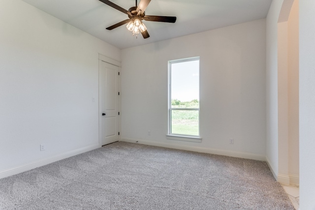 carpeted spare room featuring ceiling fan