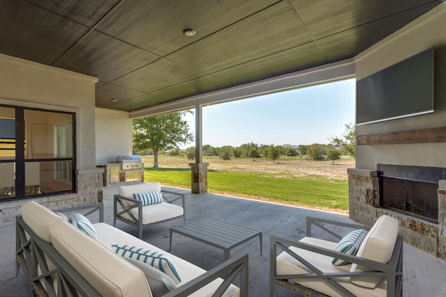 view of patio / terrace featuring an outdoor living space with a fireplace and area for grilling