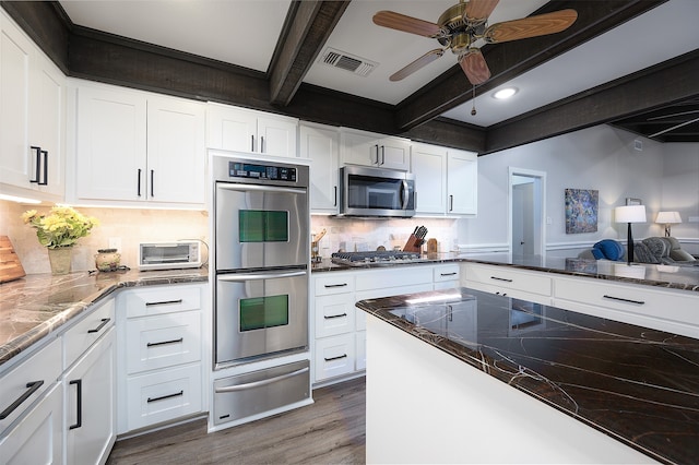 kitchen featuring appliances with stainless steel finishes, ceiling fan, light hardwood / wood-style floors, tasteful backsplash, and lofted ceiling with beams