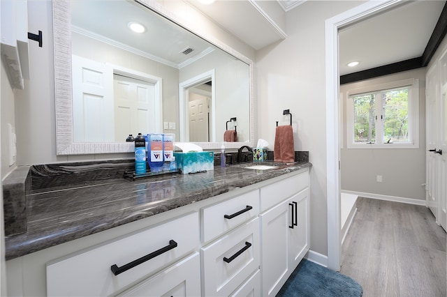 bathroom with hardwood / wood-style flooring, beam ceiling, and a washtub