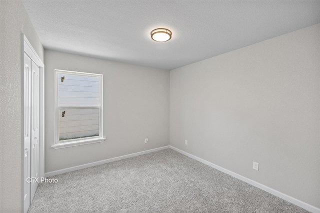 unfurnished room with light carpet and a textured ceiling