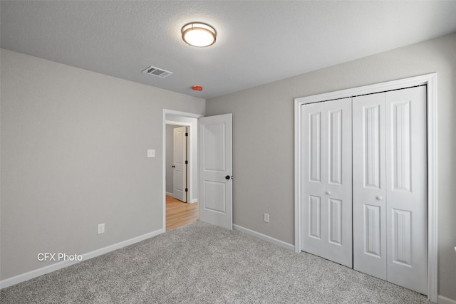 unfurnished bedroom featuring light carpet and a closet