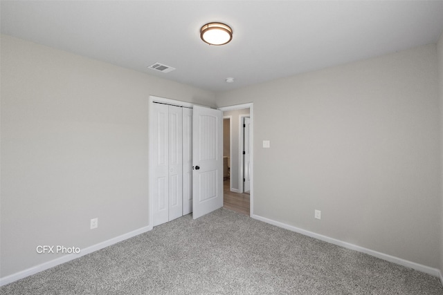 unfurnished bedroom featuring a closet and light colored carpet